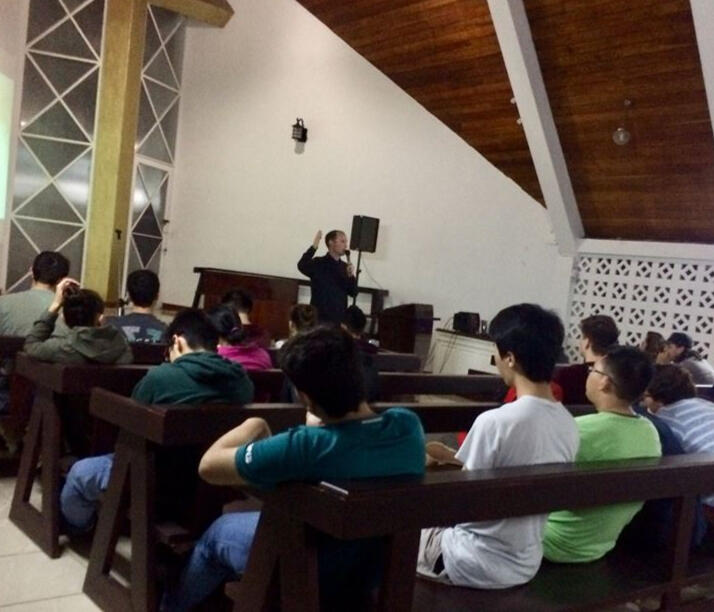 Kyle leads a devotional in the chapel for a student retreat